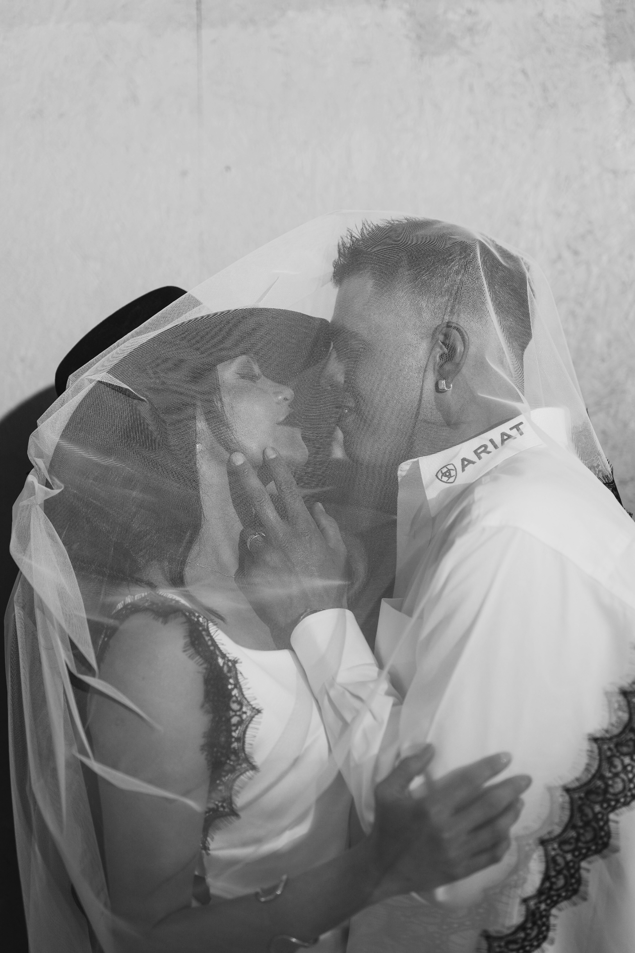 Bride and groom kissing beneath the veil