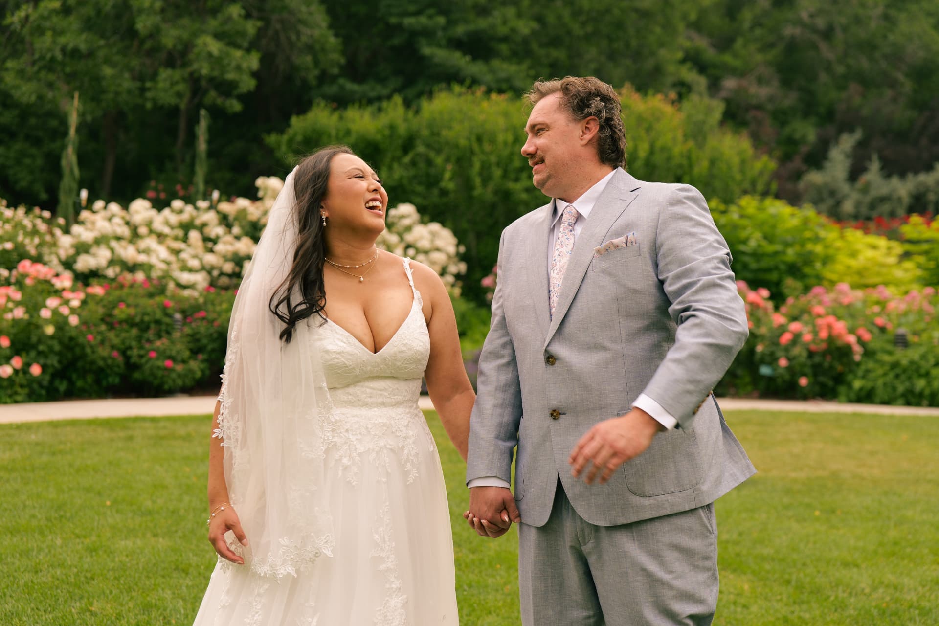 Bride and groom laughing together in a garden