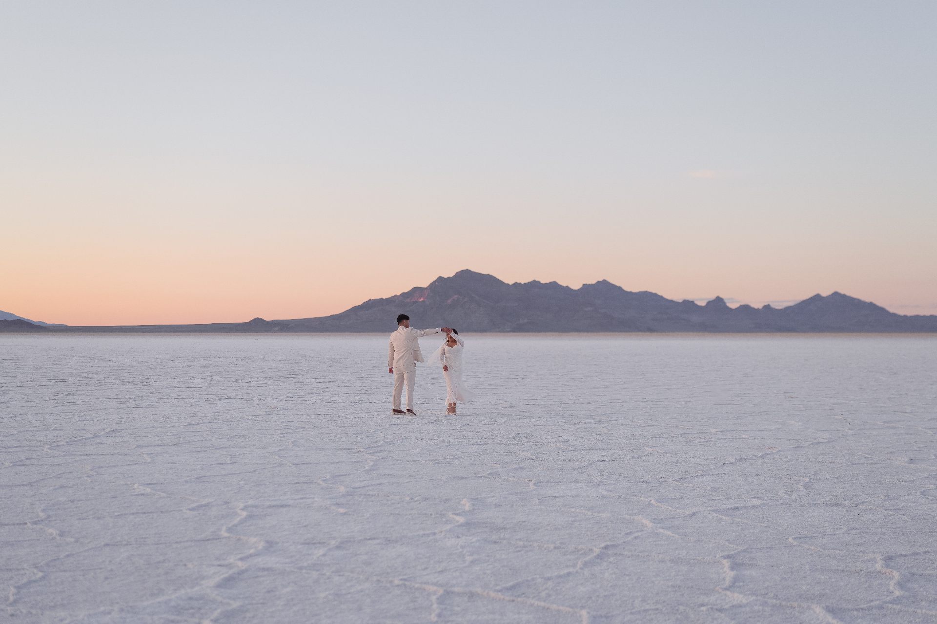 Bride and groom dancing on the salt flats at sunset