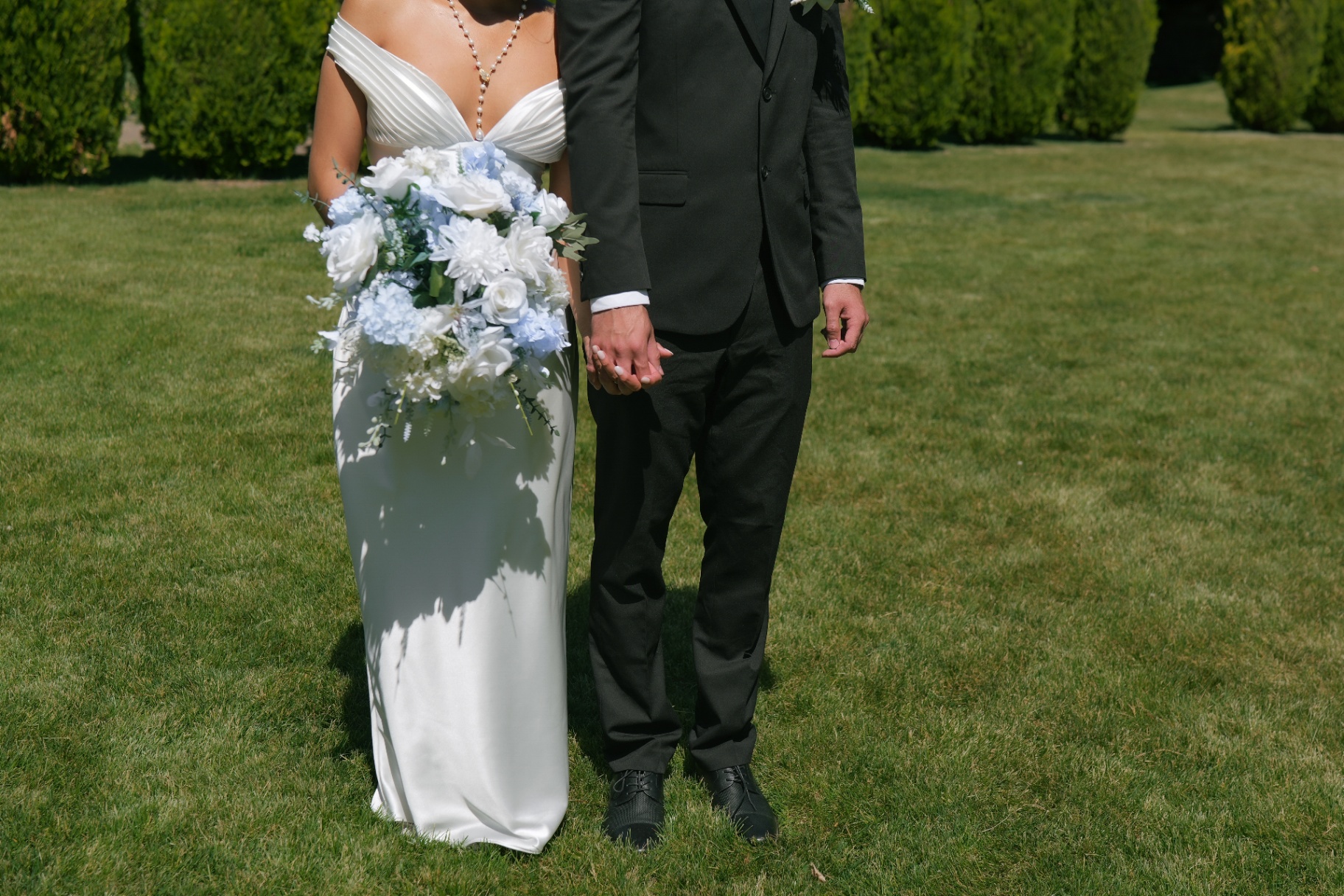 Bride and groom holding hands with a blue-and-white bouquet